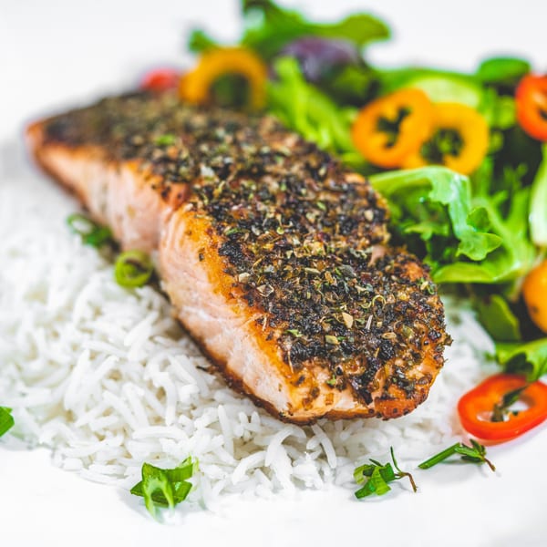 Suzie's Fusion Cuisine: Caribbean-spiced salmon fillet on white rice with a side salad.